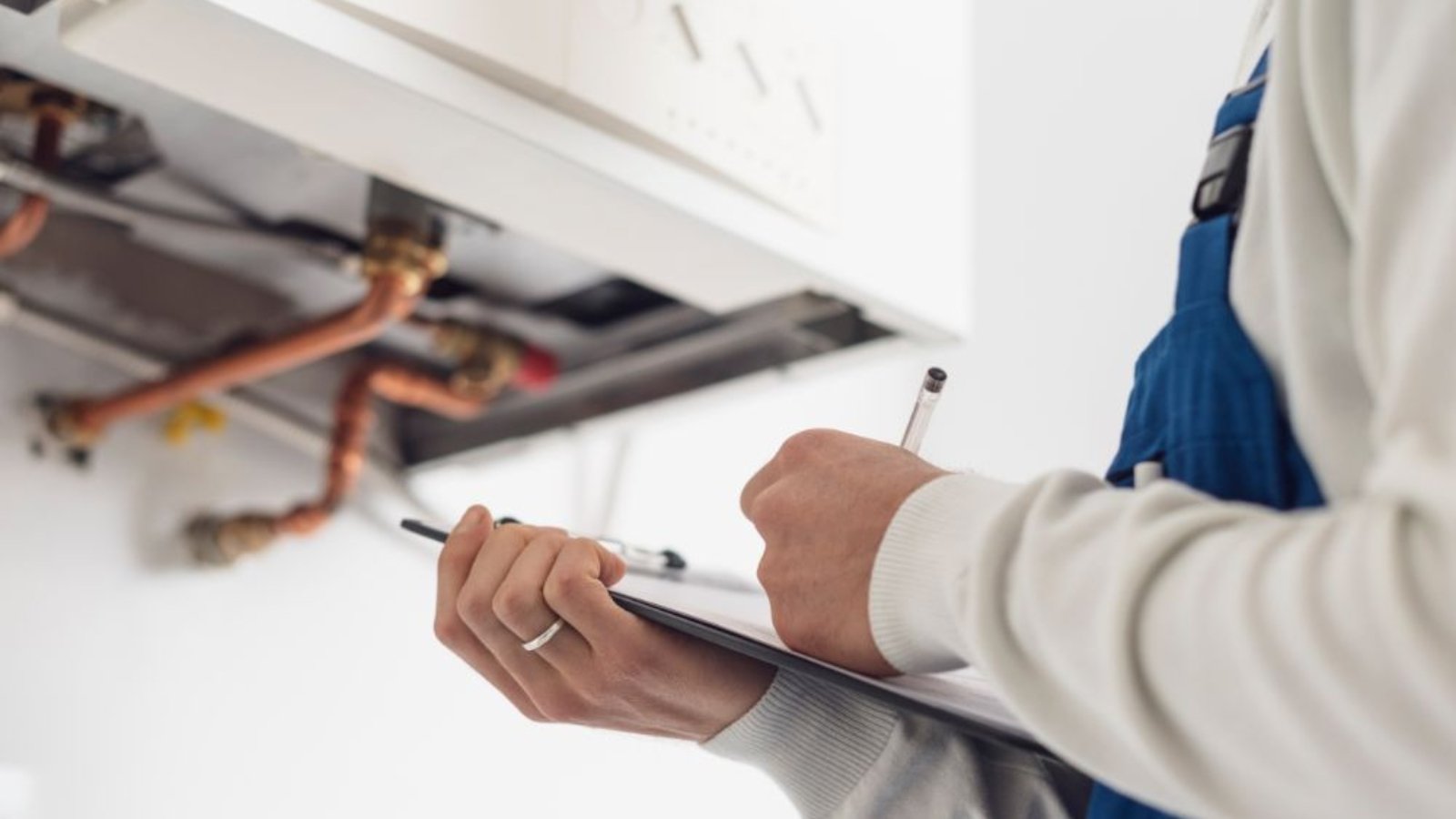 professional-plumber-doing-a-boiler-check-6MYA3MF 1